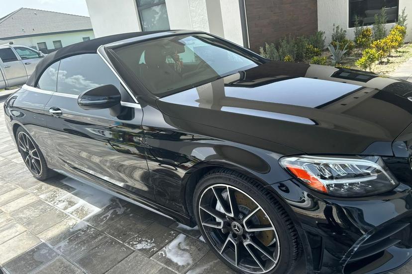 Black Mercedes-Benz convertible with a mirror-like gloss after an exterior detail
